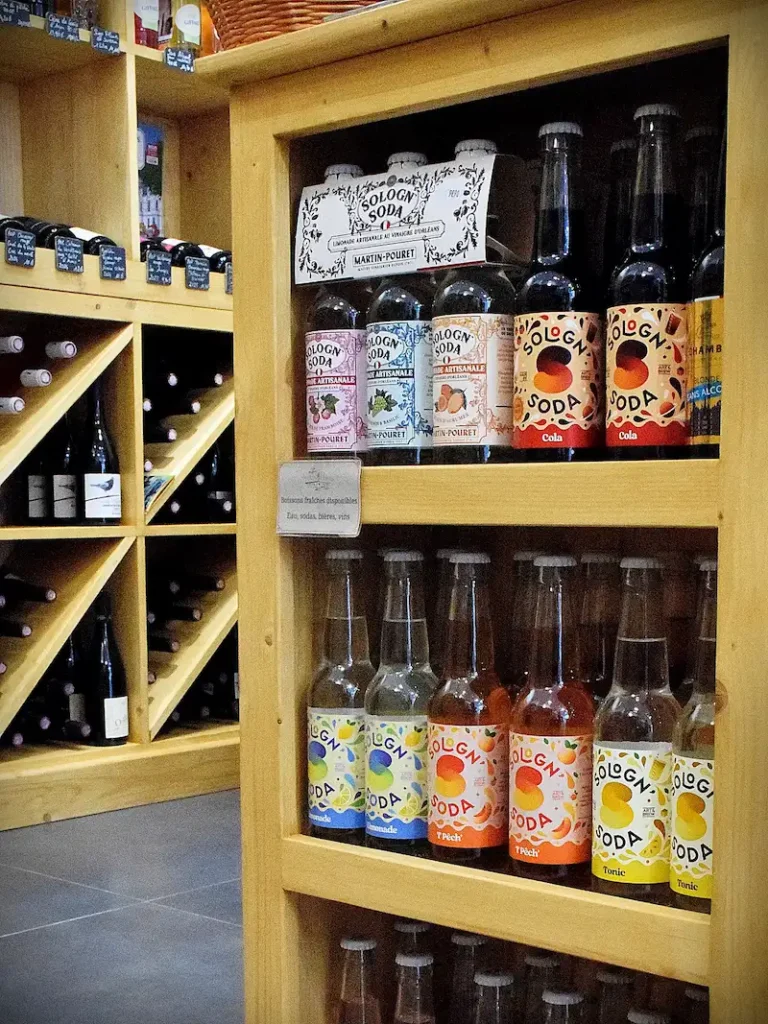 Bouteilles de sodas artisanaux sur étagères en bois